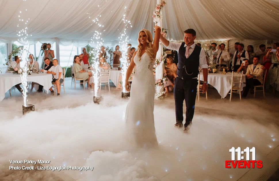 Bride, twirled by groom on white starlit led dance floor with sparks in the background and low lying clouds whilst they have their first dance at Parley Manor weddings