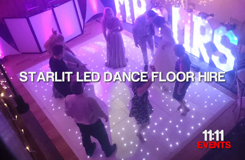 Photo of Wedding guests and Bride dancing on a 14x10ft White LED star light dance floor next to light up letters MR&MRS. Wedding Venue, the victorian Barn, Dorset