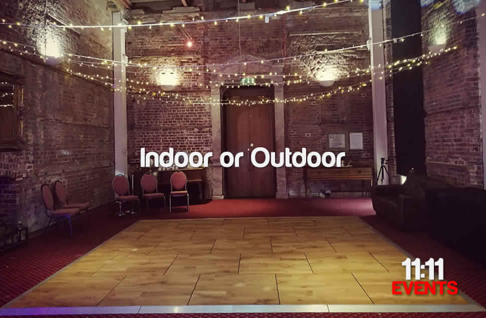 Photo of a 15x15ft oak style dance floor in Highcliffe Castle, Christchurch, on red carpet with very high stone castle walls and fairy lights hanging above