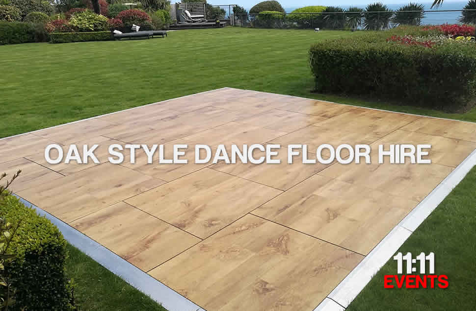 Photo of a 15x15ft oak style outdoor dance floor on a prestine green lawn, situation in a large garden overlooking the sea in Christchurch