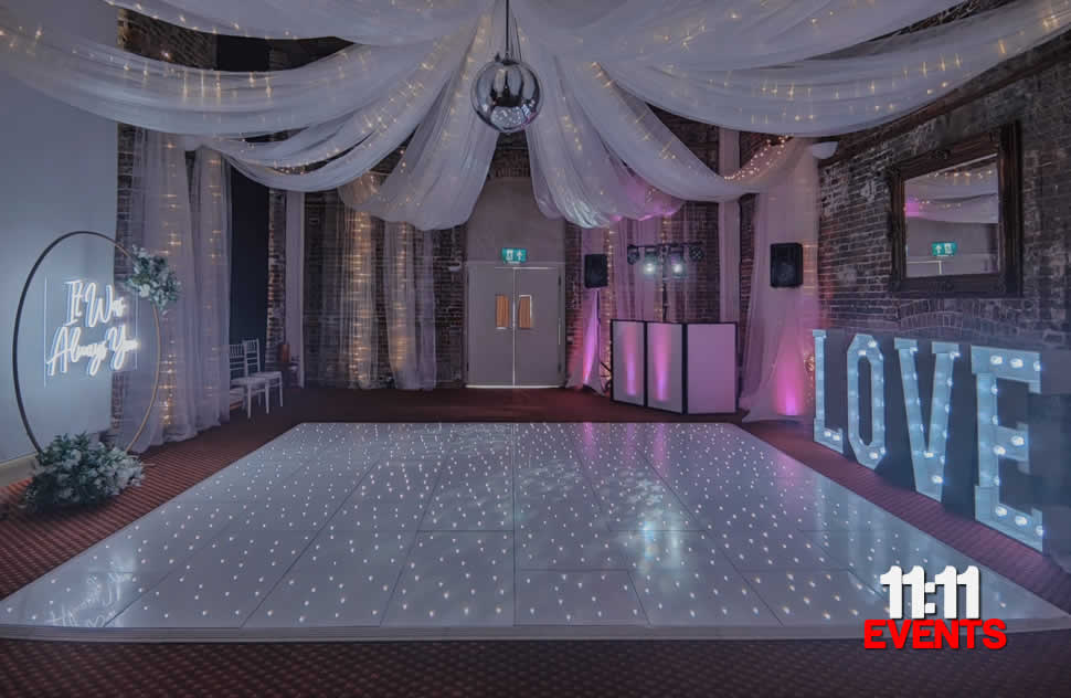 Highcliffe Castle Drawing room decorated for a wedding with a white led starlit dance floor, light up love letters, DJ equipment, drapes and a mirror ball