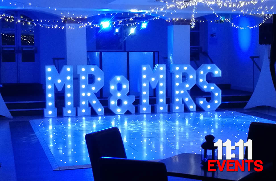 Photo of 4ft high light up MR&MRS letters, lamps on the letters are white and the room is lit with blue mood uplights, installed at The Italian Villa in Poole, Dorset.