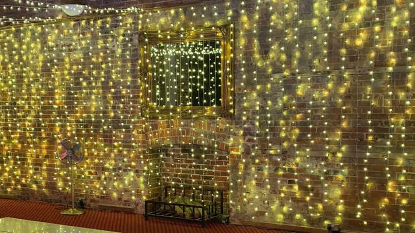 Warm white fairy light curtain draped over the brickwork at Highcliffe Castle in Hampshire