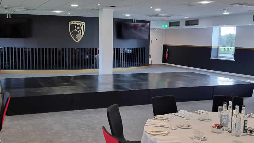 Corporate black stage riser. Setup at AFCB Bournemouth for speeches / conference