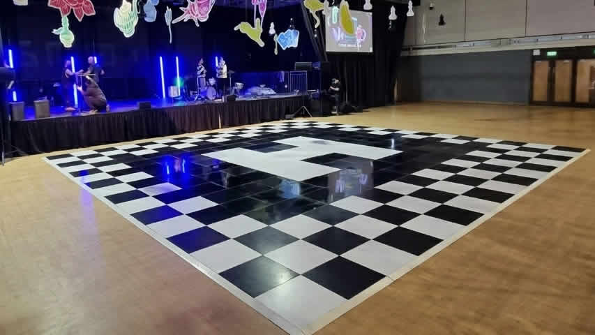 A large custom branded dance floor for Hendy at Bournemouth International Centre with chequered Alice in Wonderland theme