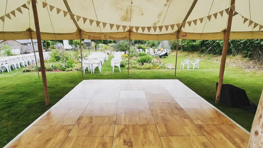 Outdoor oak effect dance floor for a garden party installed directly on grass