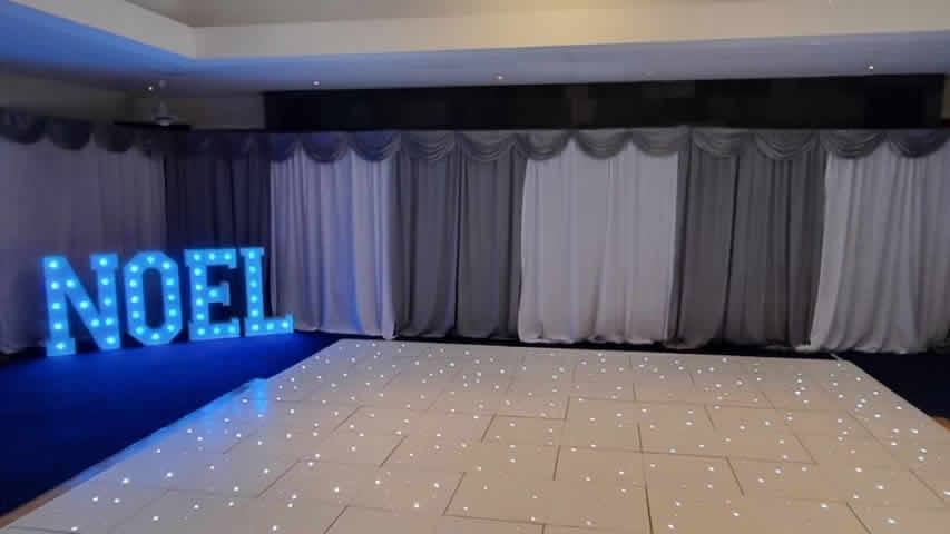 Military gala event with light up Noel Xmas letters on a white starlit dance floor at a military camp party