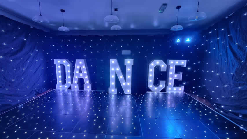 Party with black starcloth light up letters on a black starlit dance floor at Queens Park