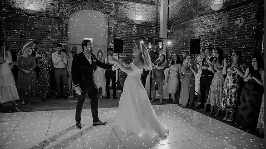 Highcliffe Castle, first dance surrounded by guests on white dance floor with DJ and mirror ball effect  